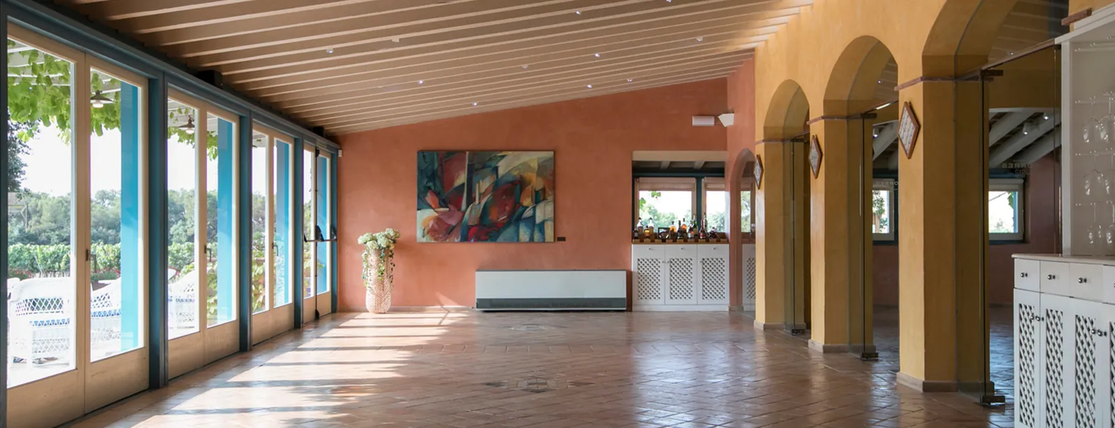 Vaulted hall of Mas Rabell with large glass doors and arches