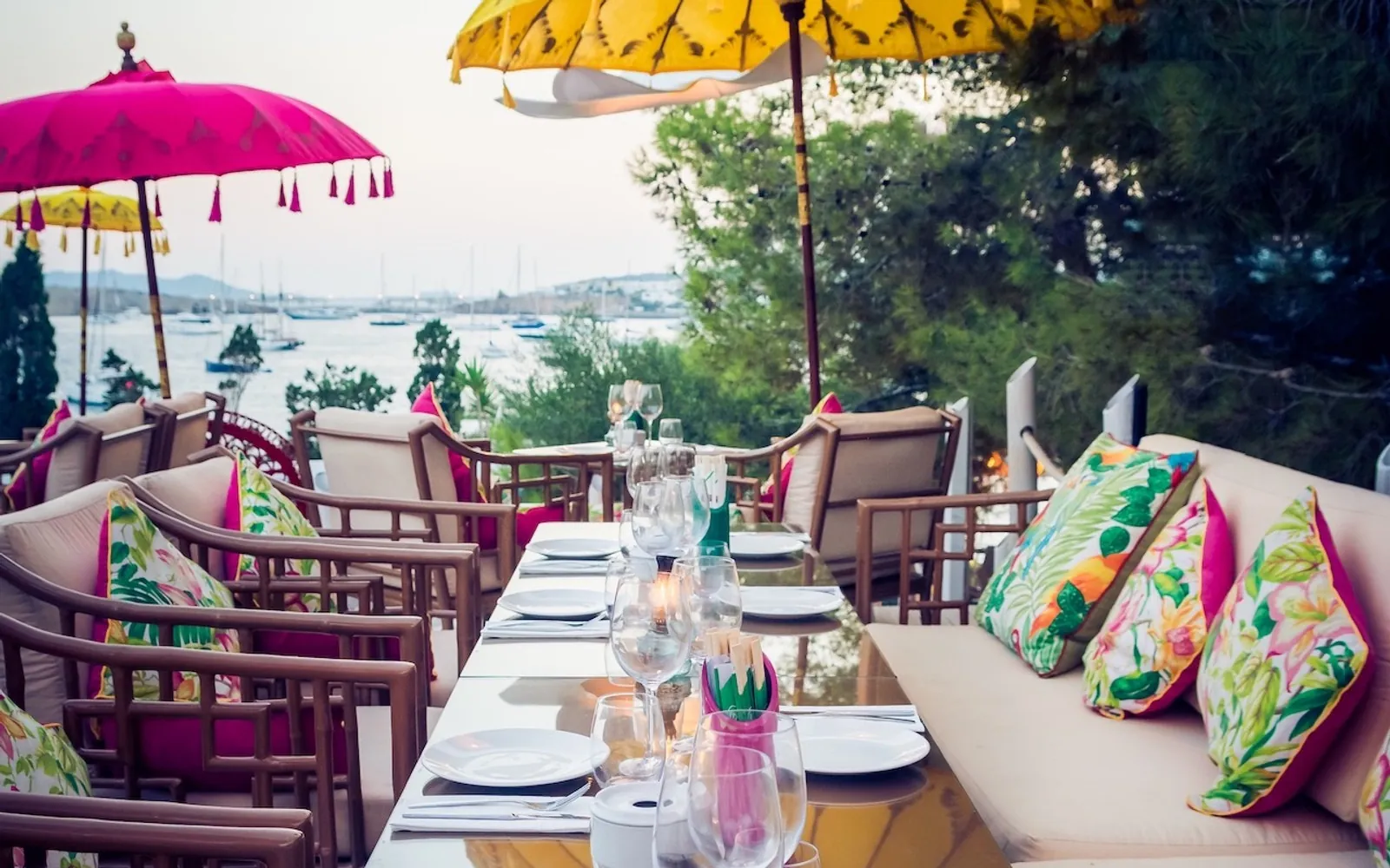 Table set on the Sa Punta terrace with flowered cushions and sea view in Ibiza