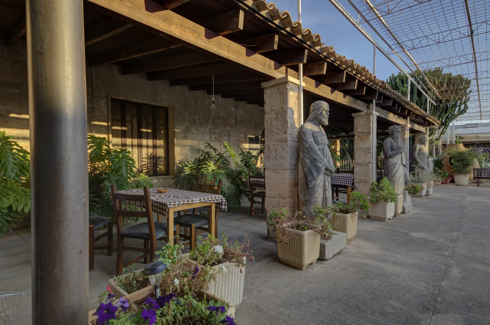 Shaded terrace of Ses Tres Germanes restaurant in Palma, outdoor tables and plants