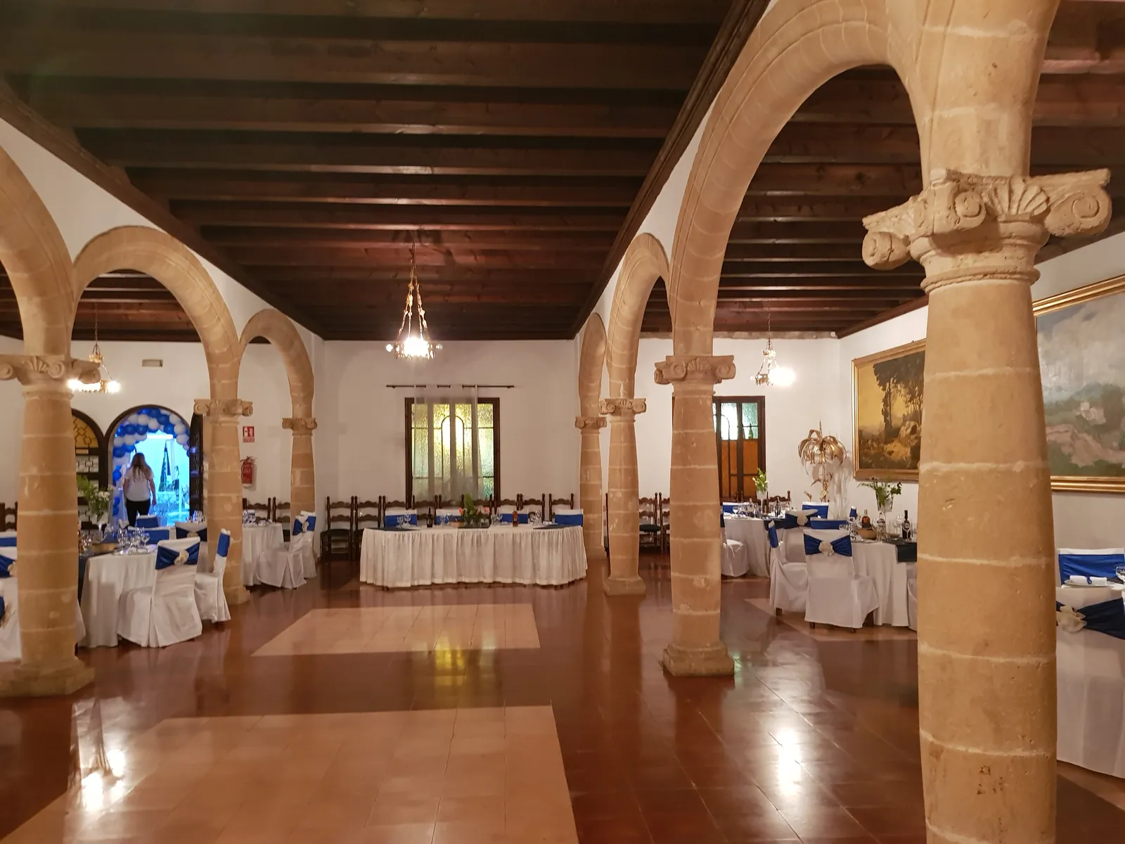 Vaulted dining hall of Ses Tres Germanes restaurant in Palma, set tables and stone columns
