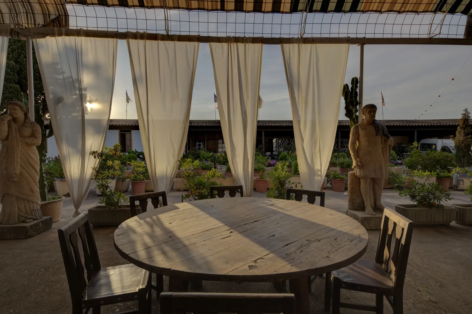 Round table under curtains in the garden of Ses Tres Germanes restaurant in Palma