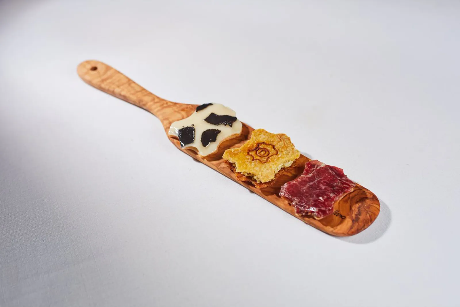 Wooden board with three colourful bites, tasting at Zaranda in Palma