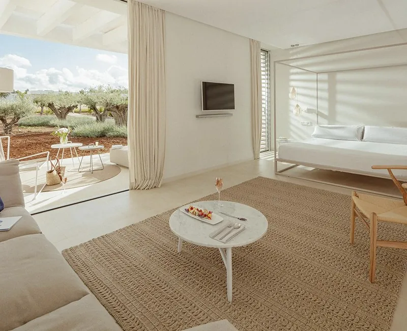 Bright suite with terrace and white furniture at Ca Na Xica, Ibiza, for team stays and events