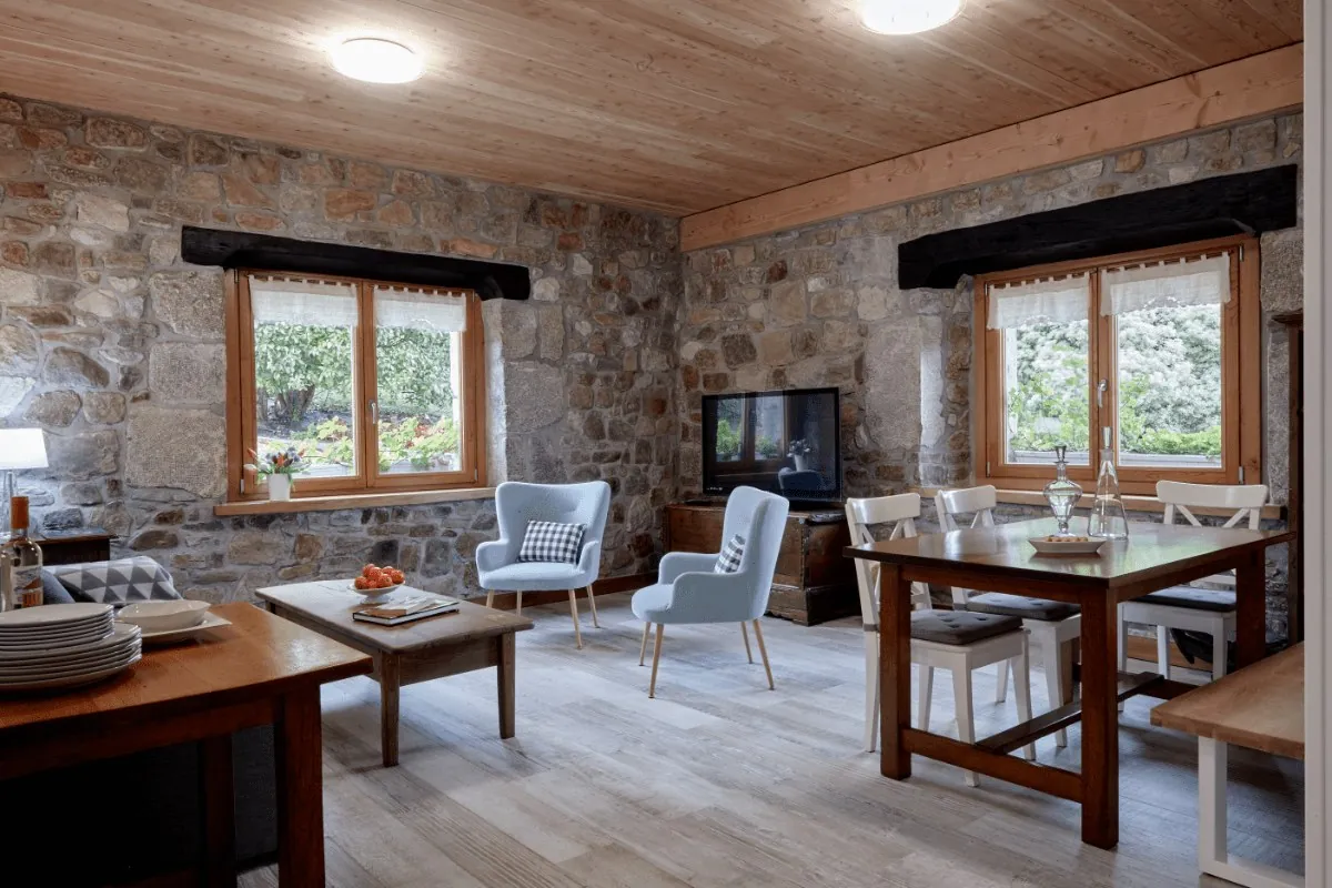 Stone and wood lounge with long meeting table at Casas de Ea Astei near Bilbao
