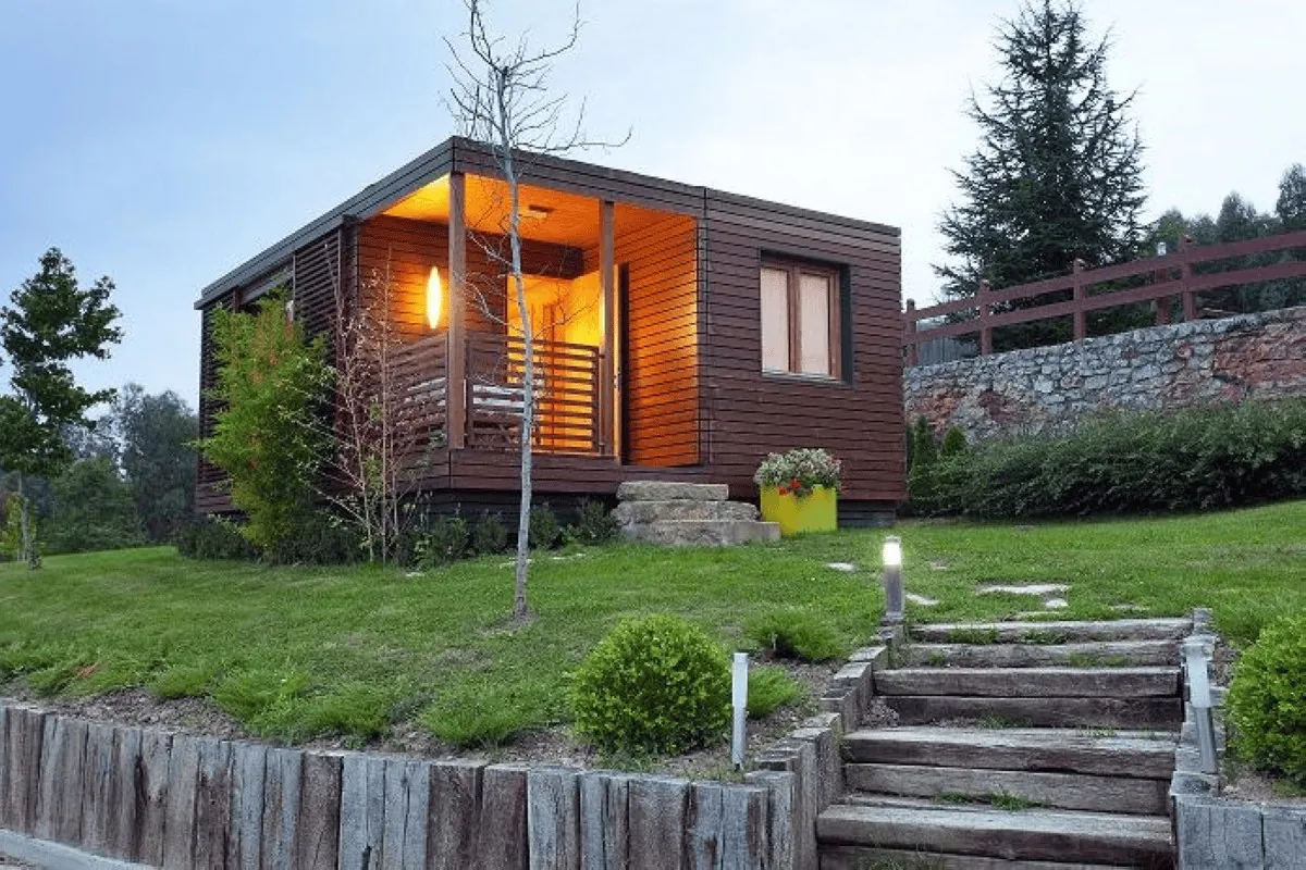 Wooden house lit up in the evening in the garden of Casas de Ea Astei near Bilbao