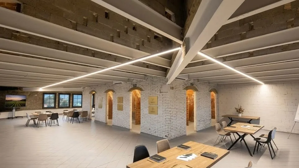Brick and wood meeting room at Cavas Codorníu in Barcelona with tables and screen