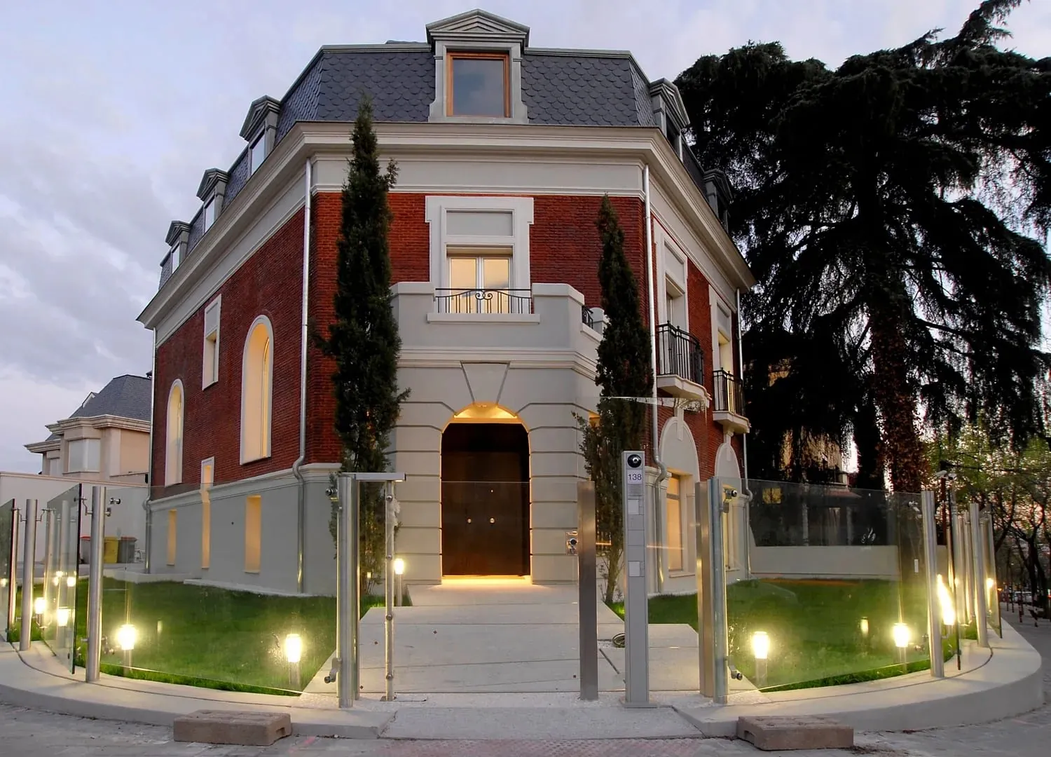 Facade of Fundación Pons in Madrid, brick villa lit in the evening