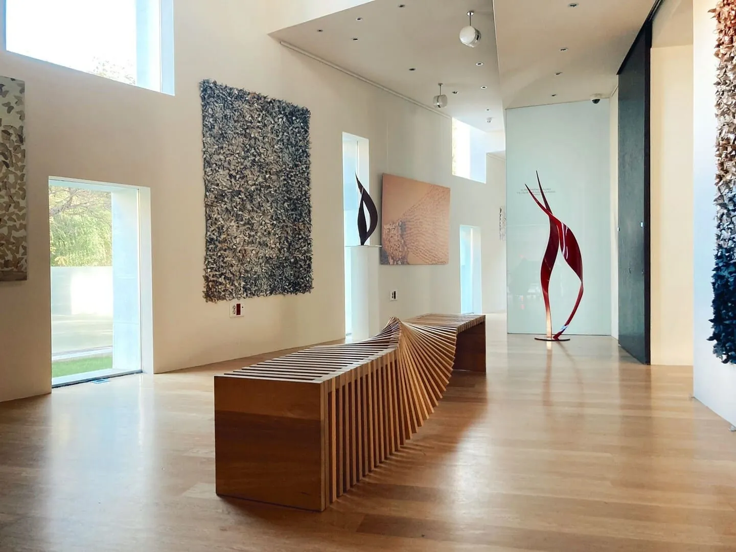 Gallery with red sculpture and wooden bench at Fundación Pons in Madrid