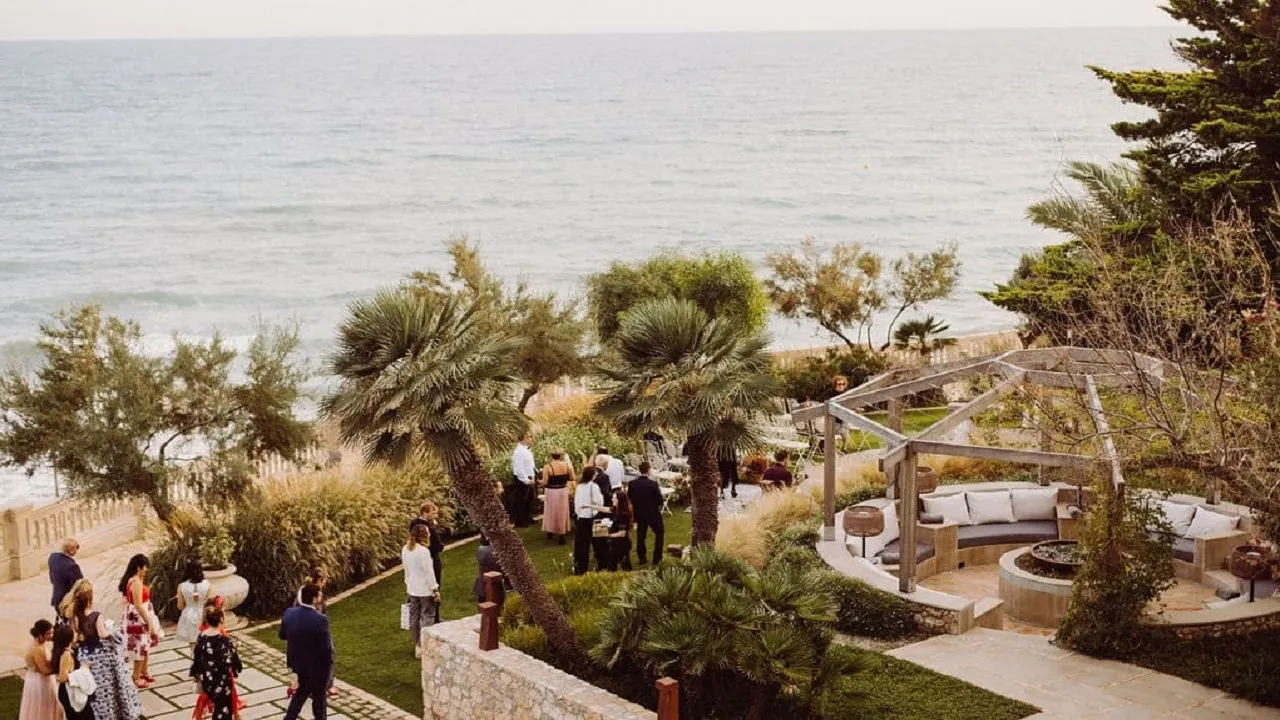 Terrace of Xalet del Nin facing the sea, guests in the garden